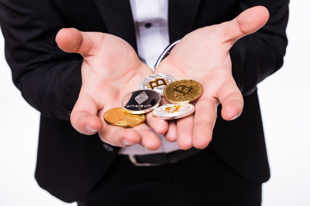 Persona sosteniendo criptomonedas monedas